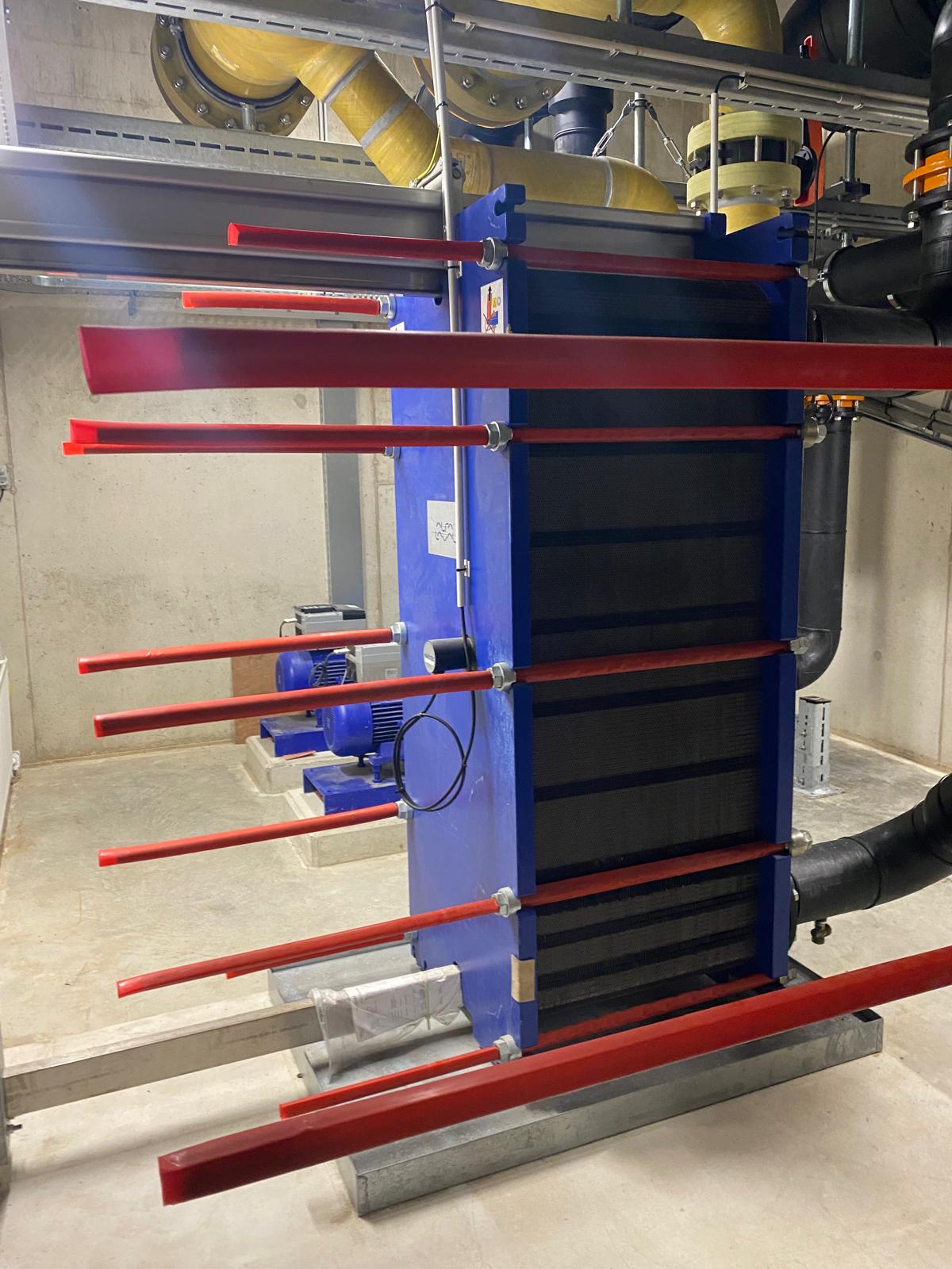 Platenwarmtewisselaar met aansluitleidingen in een installatieruimte